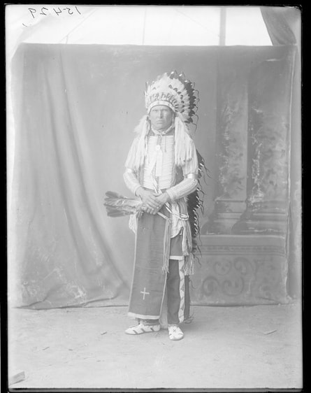 Studio portrait of Chief Jock Bull Bear in a feathered headdress
